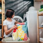 Woman putting clothes in a washing machine