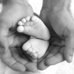 Baby’s feet in daddy’s hands