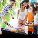 group-of-friends-having-a-barbecue-and-grill-party-in-nature-RKF4R9
