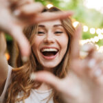 Close,Up,Of,Happy,Young,Girl,Showing,Frame,With,Fingers